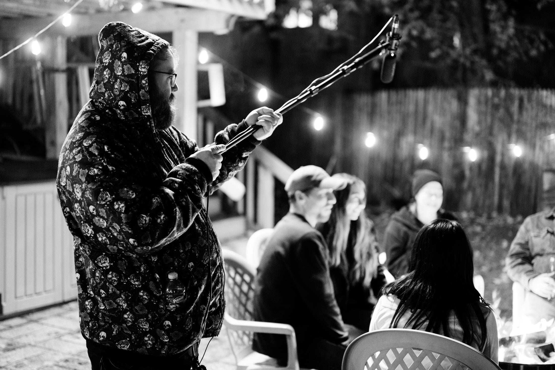 Boom operator working against the string lights